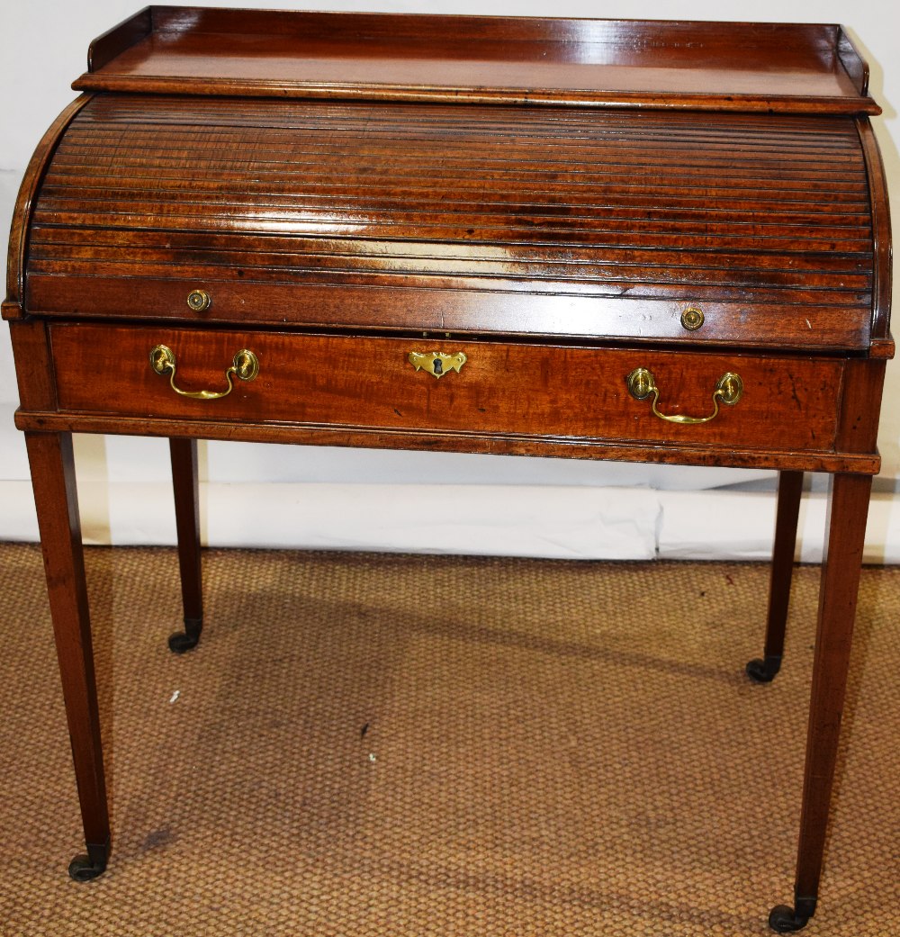 A Sheraton mahogany roll top desk, the top with a gallery above a tambour shutter fall revealing