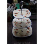 An Art Deco three tier Cake Stand having hand painted floral design on cream ground with blue