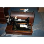 A wooden cased Singer hand sewing machine with instructions etc