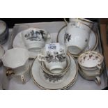 A box of various cups and saucers including floral pattern and cattle designs