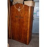 A 1950's Walnut double door fitted small Wardrobe by Woodland Products, having well figured,