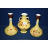 Three yellow vases with brown foliage and berry decoration,