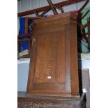 A Georgian Oak Wall hanging Corner Cupboard with moulded cornice over single moulded panel door