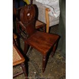 A Victorian Mahogany Hall Chair having shaped and carved back with circular motif,