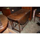 A 1940's Oak oval top Gateleg Dining Table with moulded edge top and leaves on barley twist legs