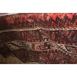 A large maroon and black Rug, 126'' x 90'' approx, badly faded,