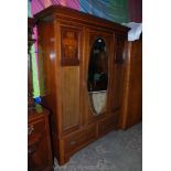 An Edwardian Mahogany single door Wardrobe with oval bevel plated mirror,