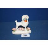 A Staffordshire Poodle figure with shells on the stand.