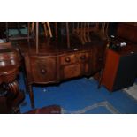 A Georgian Mahogany bow fronted Sideboard of small proportions with shaped top over central frieze