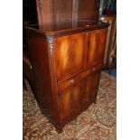 A reproduction Mahogany Georgian style Drinks Cabinet having cross banded top over fall opening to