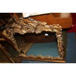 A reproduction Rococo style gilt frame Wall Mirror having ornate leaf pattern moulding with scrolls.