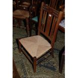 An arts and crafts Oak Nursing Chair, slat and splat back with stylised flower carving, rope seat,