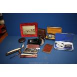 A box of miscellanea including clothes brushes, electric shavers, bakelite tobacco tin and contents,