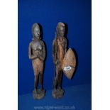 A pair of African carved wood figures depicting a Zulu style warrior with a spear and a shield and