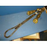 A Crupper with brass embellishments and two leather straps with brass fittings and decoration.
