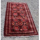 A 100% wool Iranian Mashad Balouch red ground Rug with two central rows of five gulls,