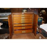 A six drawer Oak table top collector's Cabinet, 21'' tall, 22'' long,