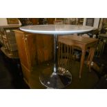 A CIRCULAR TABLE WITH CHROME BASE