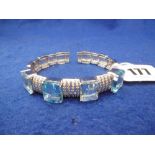 AN AQUAMARINE AND DIAMONDS BANGLE IN WHITE METAL