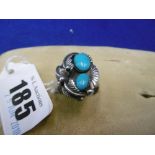 A WHITE METAL AND TURQUOISE LEAF DESIGN RING