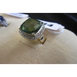 A YELLOW METAL MARKED 750 DIAMOND AND GREEN STONE COCKTAIL RING