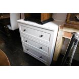 A WHITE CHEST OF DRAWERS