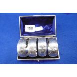 A BOXED SET OF FOUR HALL MARKED SILVER NAPKIN RINGS