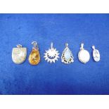 A COLLECTION OF SIX WHITE METAL PENDANTS INCLUDING AMBER