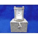 A SILVER PLATED MINIATURE CARRIAGE CLOCK IN BOX