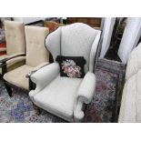 AN UPHOLSTERED WING ARMCHAIR ON BALL AND CLAW FEET