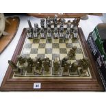 A CAST METAL CHESS SET AND BOARD,