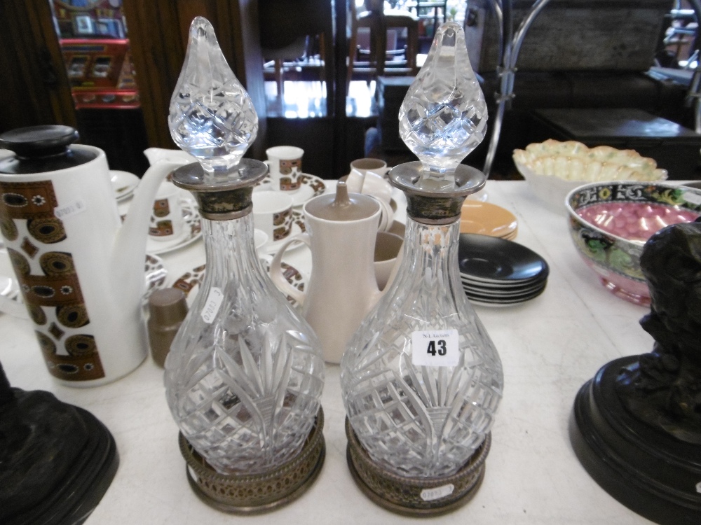 A PAIR OF CUT GLASS DECANTERS WITH SILVER COLLARS