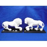 A PAIR OF MARBLED LIONS ON PLINTHS