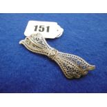 A WHITE METAL DIAMOND SET BOW BROOCH MARKED 14K