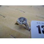 A 0.90 CARET BRILLIANT CUT DIAMOND SOLITAIRE PLATINUM RING WITH DIAMOND SET HALO AND SHOULDERS (0.