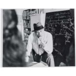 Beuys, Joseph - - Beuys vor einem Tisch mit Papieren stehend. Original-Photographie. Vintage.