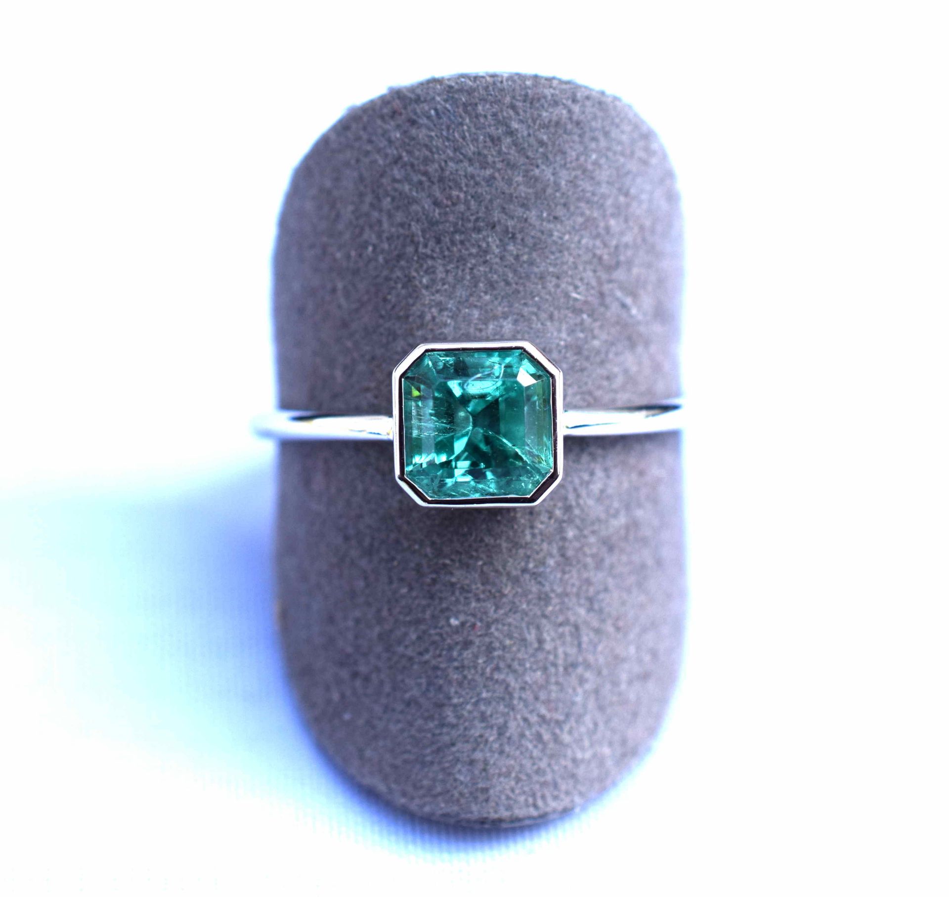 Bague or blanc centrée en clos d'une émeraude Colombie au vert profond et lumineux [...]