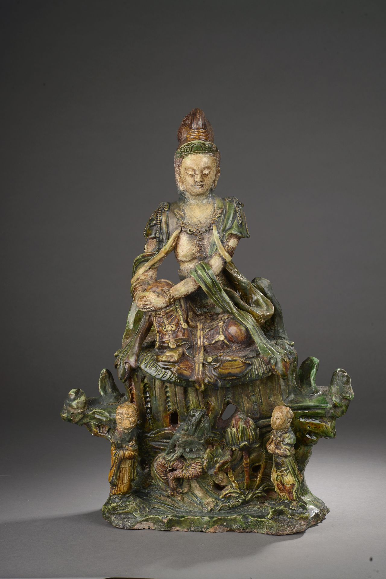 Le Boddhisattva Kwan Yin assis en délassement sur un haut tertre moulé à la base [...]