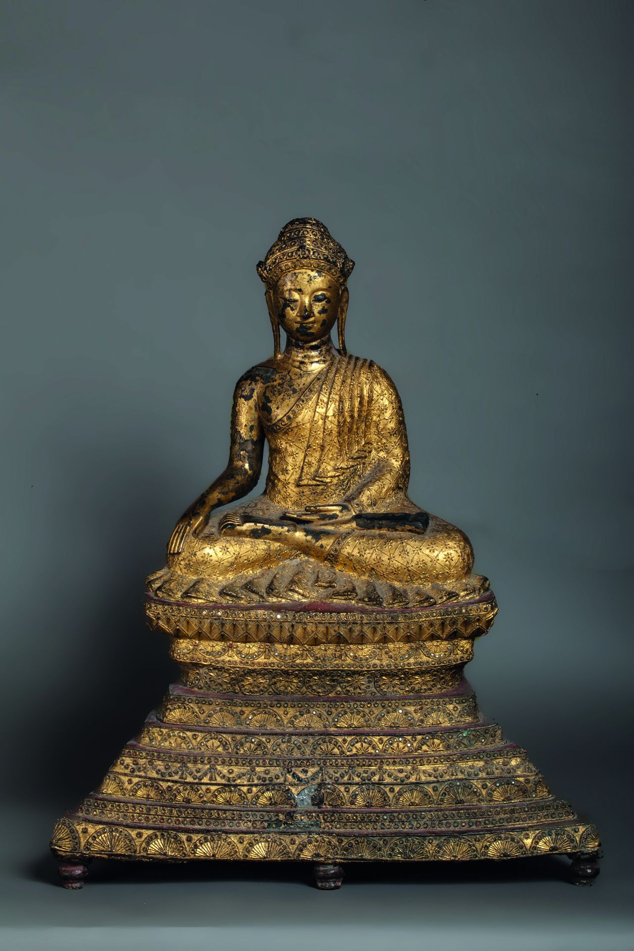 Buddha Maravijaya assis sur une base lotiforme supporté par un haut socle pyramidale [...]