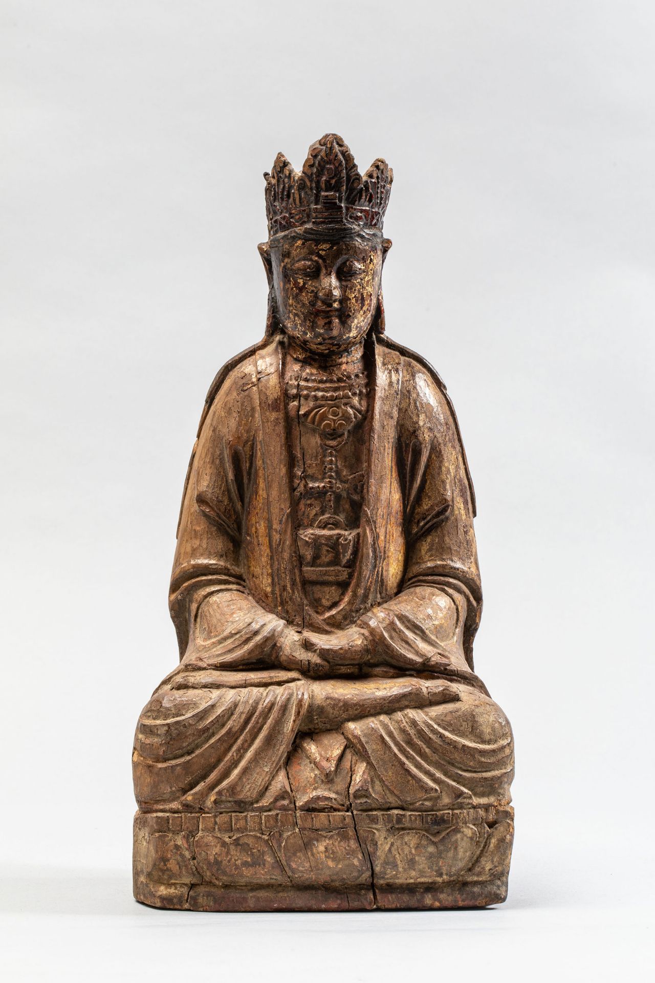 Le Boddhisattva Kwan Yin assis en méditation paré d'une couronne à pétales et [...]