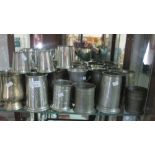 Shelf of assorted pewter tankards