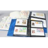 Two albums of world stamps along with two folders of foreign first day covers.