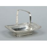 An Edwardian silver pierced cake basket with reeded swing handle by Henry Atkin.