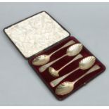 A cased assembled set of Georgian silver gilt berry spoons and sifting spoon.