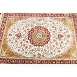 A large ivory and gold ground woven bamboo silk carpet with a traditional medallion and red ground