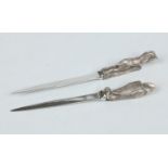 Two paper knives with silver plated terminals in novelty form,