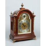 A large Edwardian mahogany bracket clock. With brass pineapple finials, mounts and paw feet.