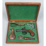 A cased early 19th century percussion cap box lock pocket pistol and accoutrements.