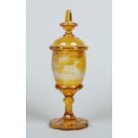 A 19th century Bohemian amber glass pedestal vase and cover.