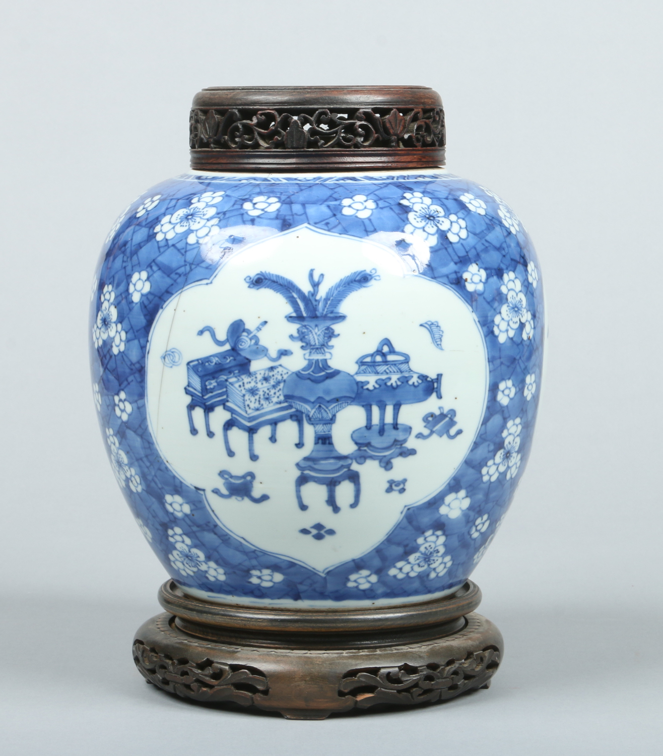 A Chinese Kangxi (1662-1722) blue and white ginger jar with pierced hardwood cover and stand.